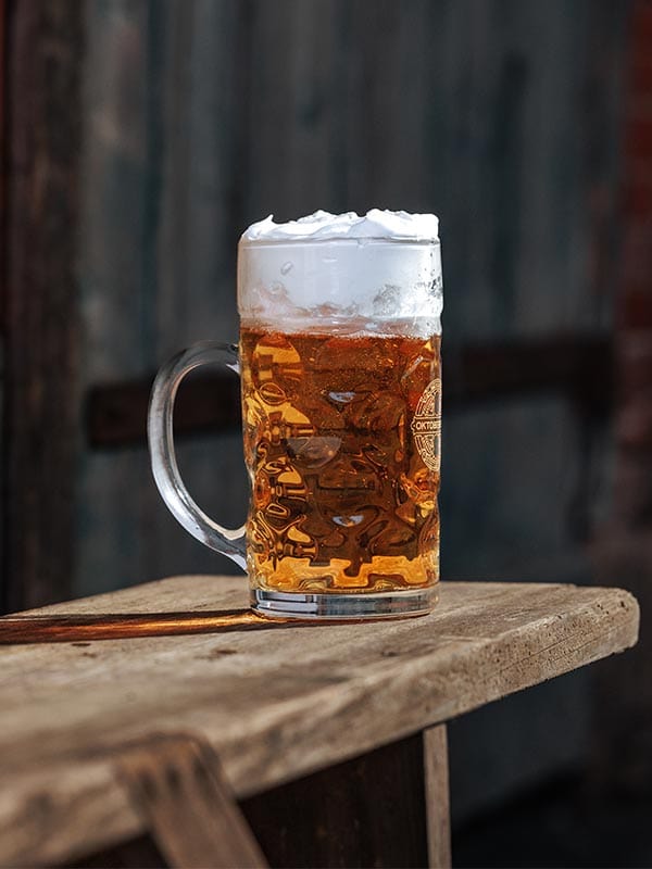 Glass mug with beer on a wooden surface